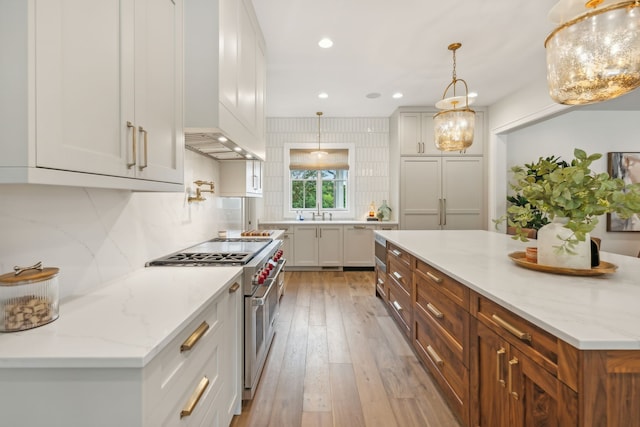 kitchen featuring custom range hood, light stone countertops, light wood-type flooring, and high end appliances