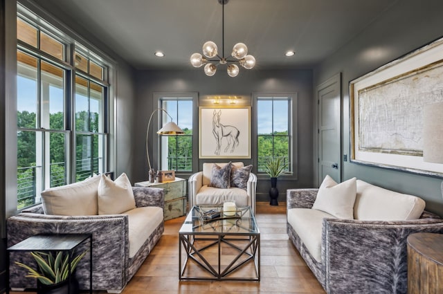 living area with light hardwood / wood-style floors, a notable chandelier, and a healthy amount of sunlight