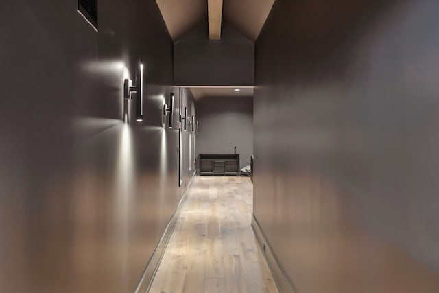 hallway with lofted ceiling with beams and light hardwood / wood-style floors