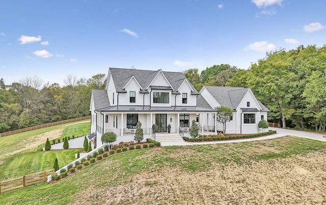 modern inspired farmhouse with a front lawn and covered porch