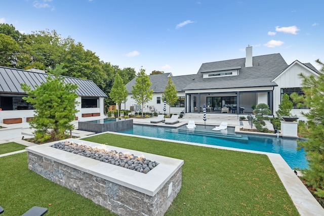 view of pool featuring a yard, a sunroom, an in ground hot tub, and a patio