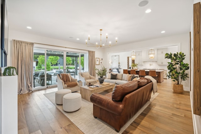 living room featuring an inviting chandelier and light wood-type flooring