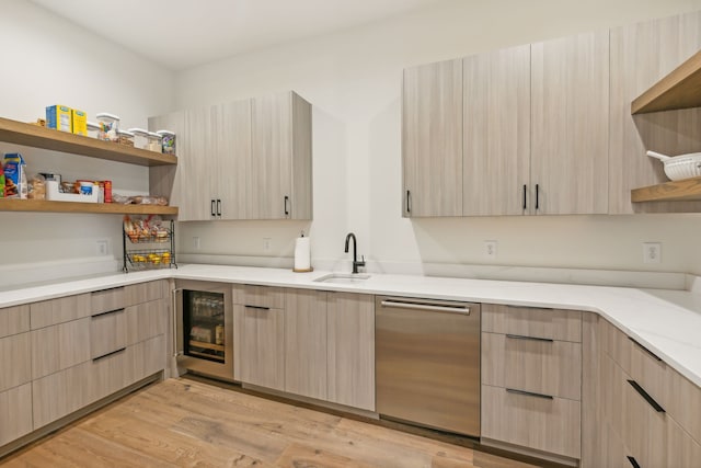 kitchen featuring wine cooler, sink, light brown cabinetry, and light wood-type flooring