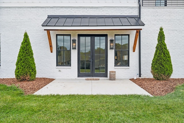 view of exterior entry featuring a patio area, french doors, and a yard