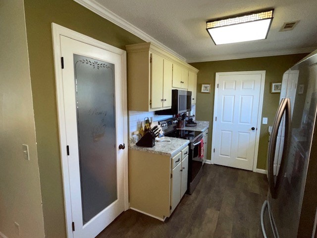 kitchen with stainless steel appliances, dark hardwood / wood-style flooring, a textured ceiling, ornamental molding, and cream cabinetry