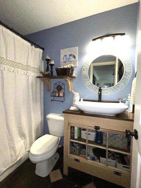 bathroom featuring toilet, a shower with curtain, vanity, and a textured ceiling