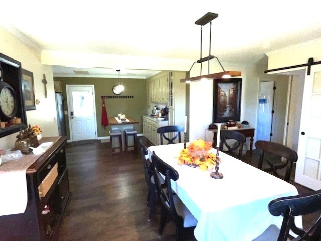 dining space featuring dark hardwood / wood-style flooring and a barn door