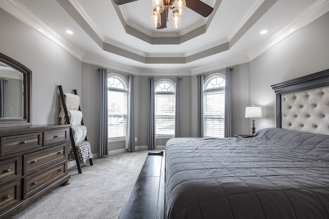 bedroom with ornamental molding, a tray ceiling, baseboards, and light colored carpet