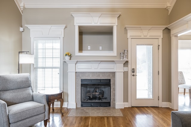 living room featuring a wealth of natural light, crown molding, and wood finished floors