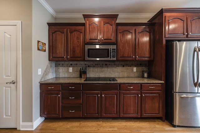 kitchen featuring decorative backsplash, dark stone counters, stainless steel appliances, crown molding, and light wood-type flooring