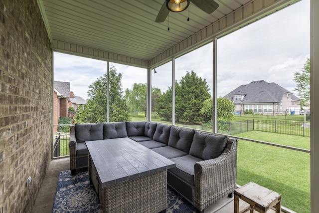 sunroom with ceiling fan and a residential view