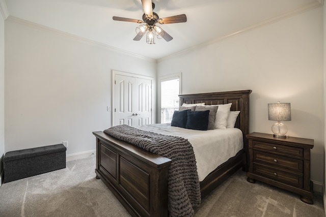 bedroom with ceiling fan, baseboards, ornamental molding, a closet, and carpet