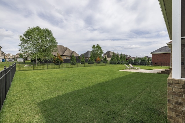 view of yard with a residential view, a fenced backyard, and a patio