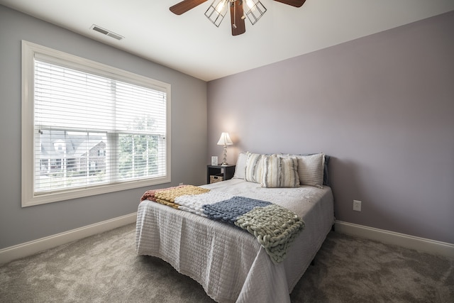 carpeted bedroom featuring visible vents, baseboards, and a ceiling fan