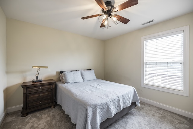 carpeted bedroom featuring baseboards, visible vents, and a ceiling fan