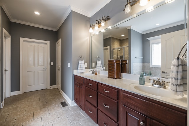 bathroom with double vanity, ornamental molding, a stall shower, and a sink