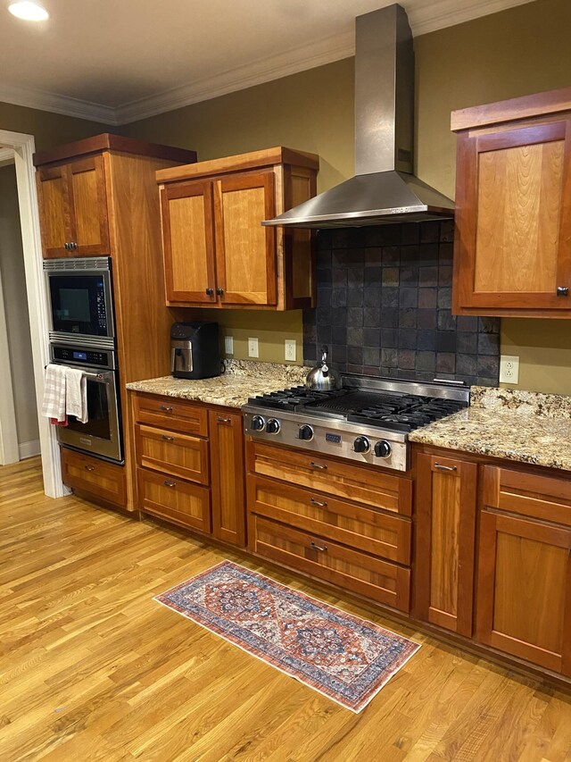 2271 Timberwood Trce, Monteagle, TN 37356 - kitchen featuring brown cabinets, light wood-type flooring, wall chimney exhaust hood, and stainless steel appliances