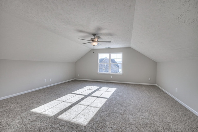 bonus room featuring ceiling fan, lofted ceiling, carpet, and a textured ceiling