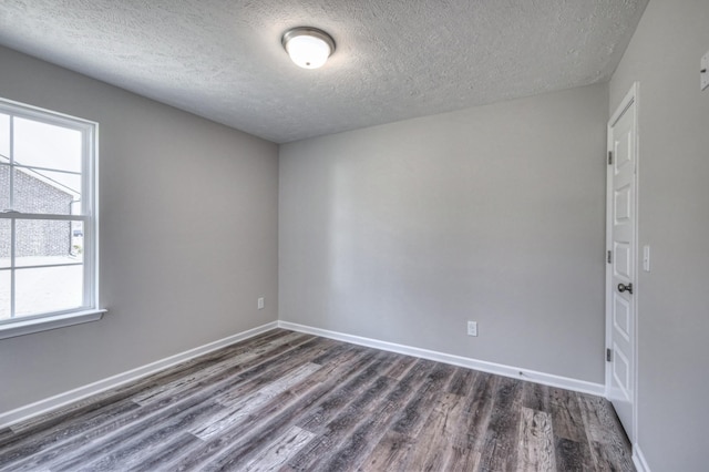 unfurnished room with dark hardwood / wood-style floors and a textured ceiling