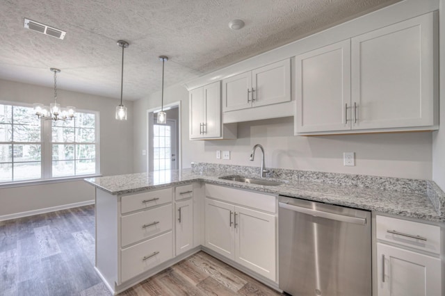 kitchen with white cabinetry, sink, stainless steel dishwasher, and kitchen peninsula