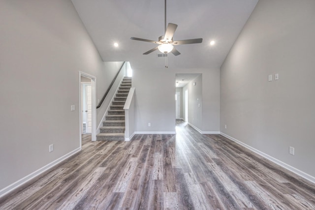 unfurnished living room with dark wood-type flooring, ceiling fan, and high vaulted ceiling