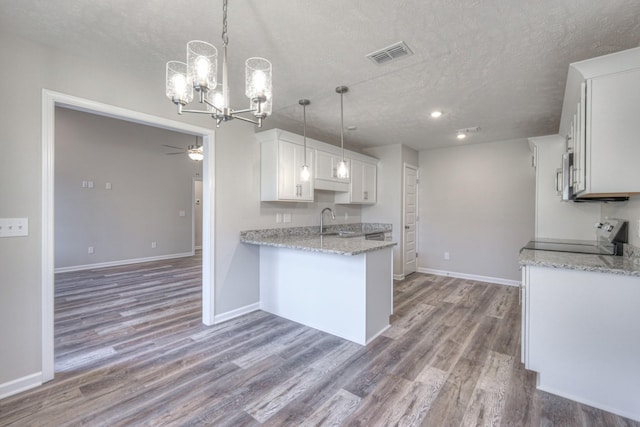 kitchen with white cabinetry, sink, pendant lighting, and range