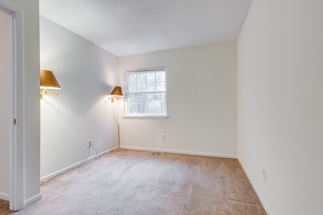 carpeted spare room with a textured ceiling