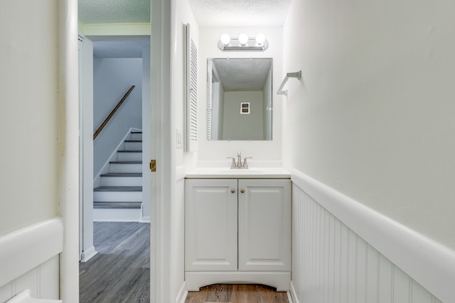 bathroom with vanity, a textured ceiling, and hardwood / wood-style floors