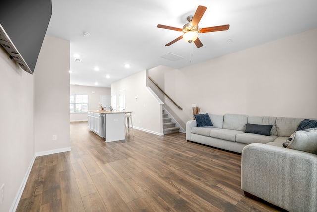 living room with sink, hardwood / wood-style flooring, and ceiling fan