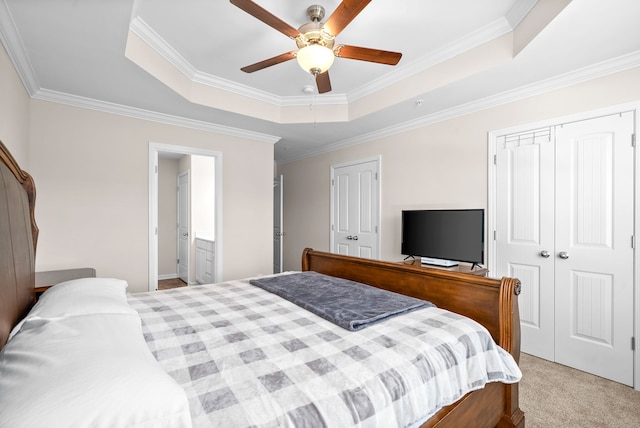 bedroom featuring crown molding, light carpet, a tray ceiling, and ceiling fan