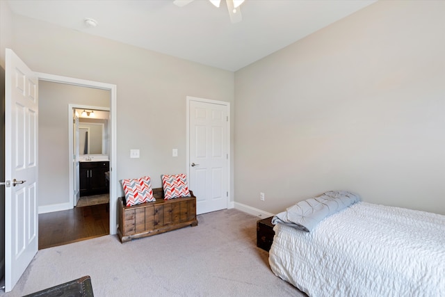 carpeted bedroom with ensuite bath and ceiling fan