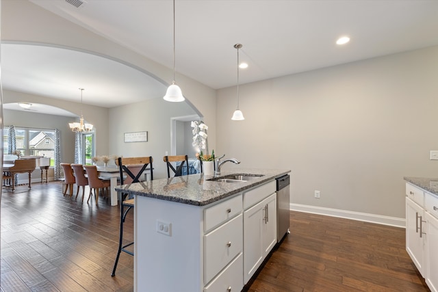 kitchen with a kitchen island with sink, light stone counters, dark hardwood / wood-style floors, and white cabinets