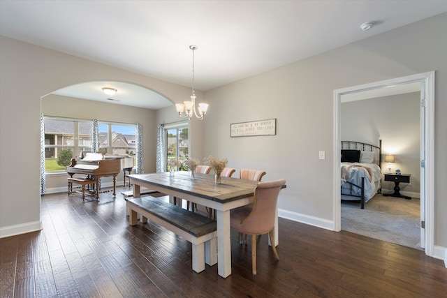 dining area with an inviting chandelier and dark wood-type flooring