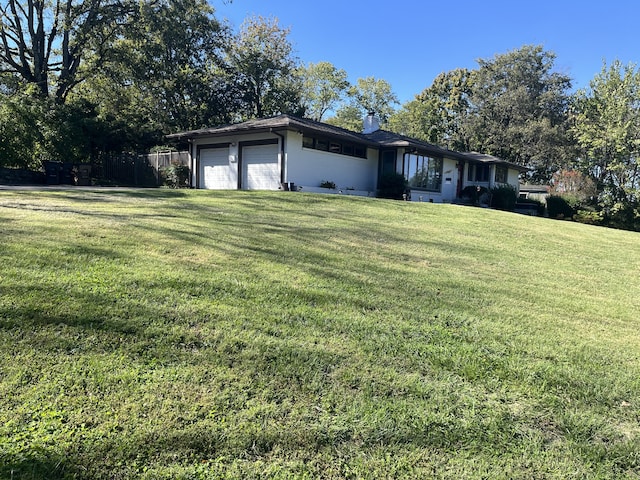 ranch-style house with a garage and a front lawn