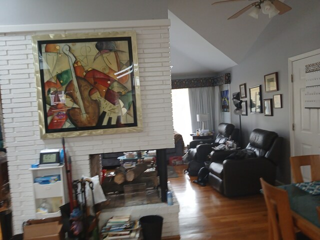 living room featuring lofted ceiling, hardwood / wood-style floors, and ceiling fan