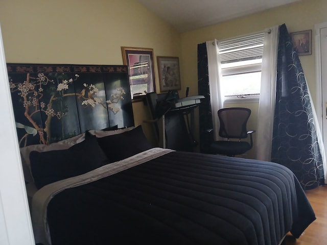 bedroom featuring hardwood / wood-style floors and vaulted ceiling