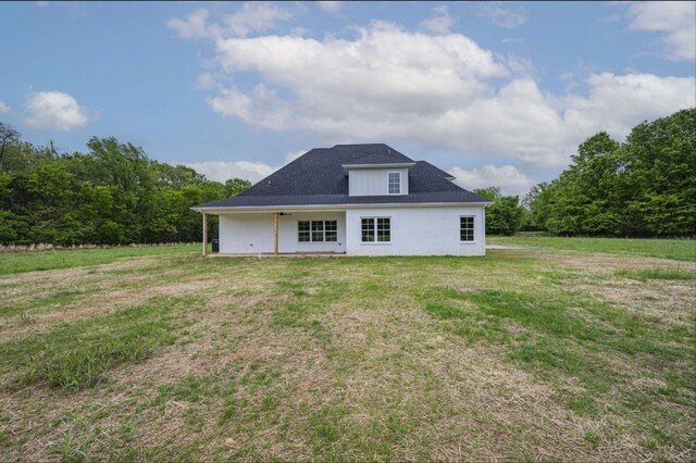 rear view of property featuring a lawn