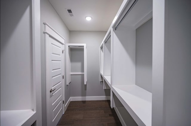 walk in closet with dark hardwood / wood-style floors