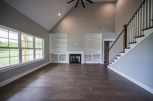 unfurnished living room featuring dark wood-type flooring, built in features, high vaulted ceiling, and ceiling fan