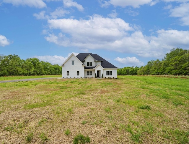 view of front of property featuring a front yard and a rural view