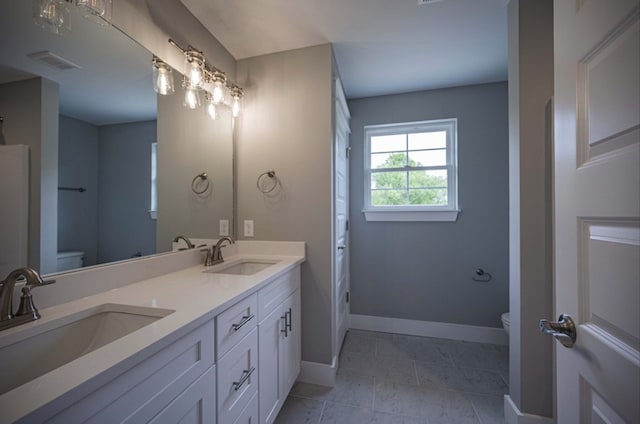 bathroom with vanity, toilet, and tile patterned flooring