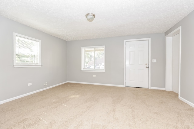 unfurnished room featuring carpet floors and a textured ceiling