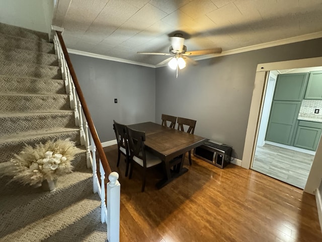 dining area featuring crown molding, wood-type flooring, and ceiling fan