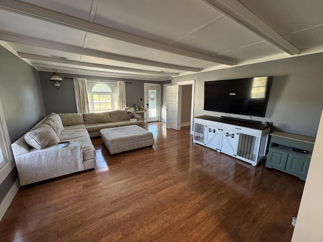 living room featuring beamed ceiling and dark hardwood / wood-style flooring