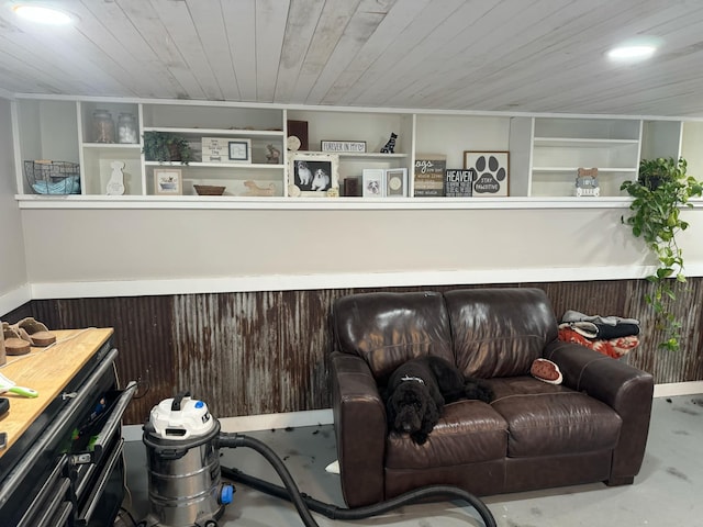 living room with concrete floors, wooden walls, and wooden ceiling