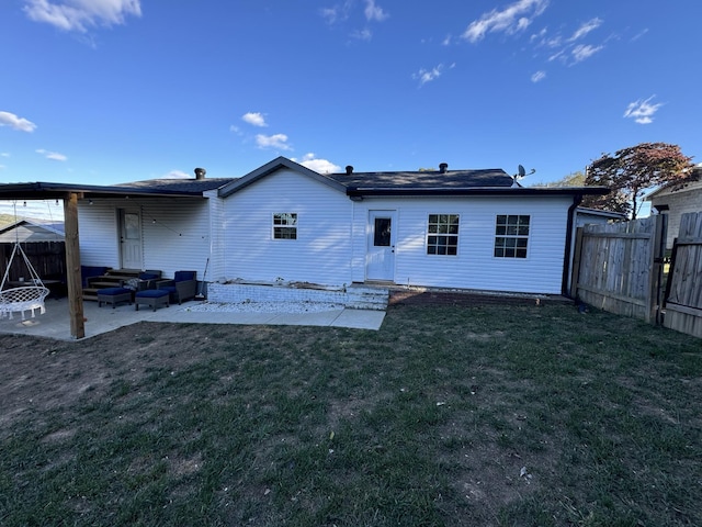 back of property featuring an outdoor living space, a patio, and a lawn