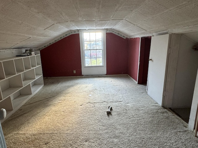 bonus room with carpet floors and vaulted ceiling