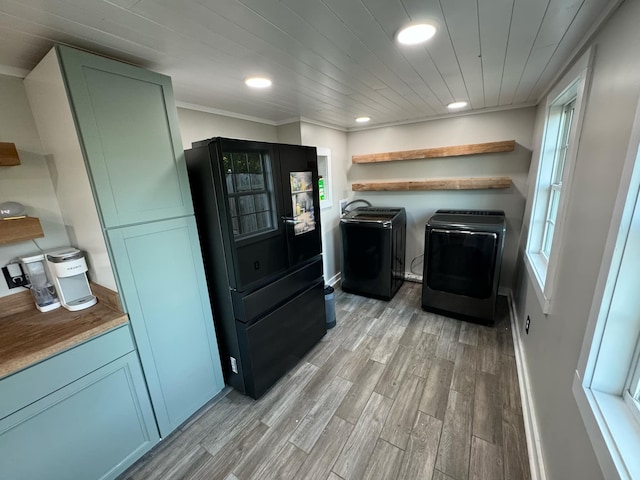 laundry area featuring ornamental molding, light hardwood / wood-style flooring, washing machine and clothes dryer, and heating unit