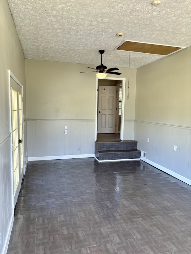 empty room featuring dark parquet floors and a textured ceiling