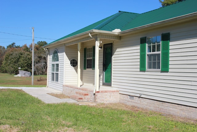 view of exterior entry with a yard